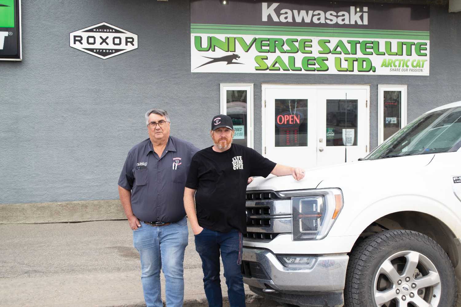 Stan and Ian Langley with their truck in front of Universe Satellite Sales.